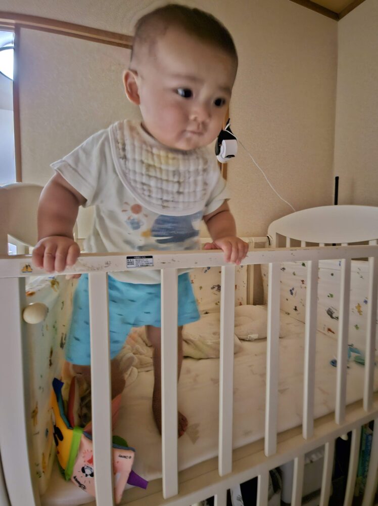 ベビーベッドでつかまり立ちをする様子